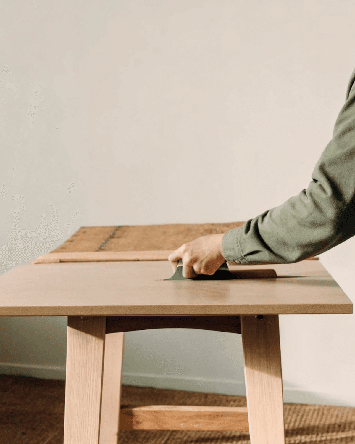 A craftsman sanding a timber panel by hand before finishing
